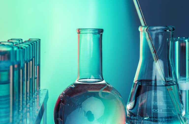 Laboratory chemistry glassware on green toned background